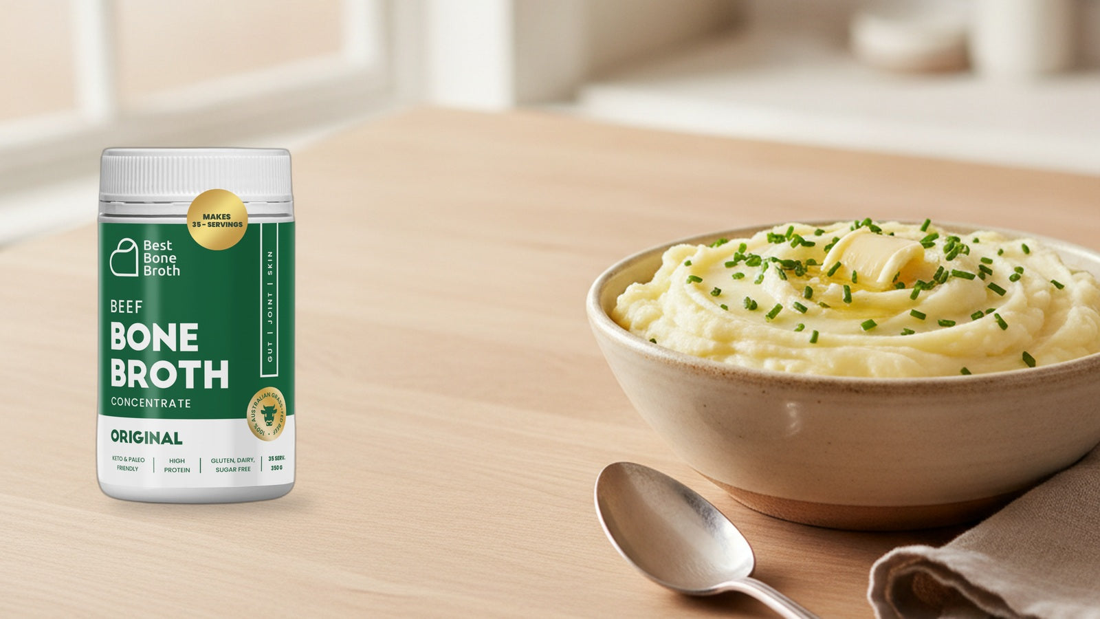Best Bone Broth Original Beef concentrate bottle beside a bowl of creamy mashed potatoes topped with chives.