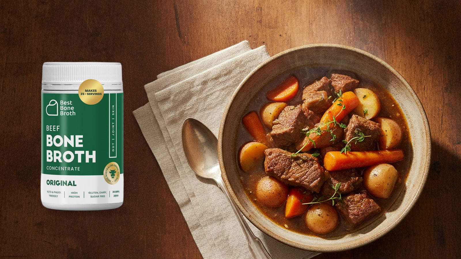Best Bone Broth Original Beef concentrate bottle beside a bowl of beef and vegetable stew on a rustic wooden table.